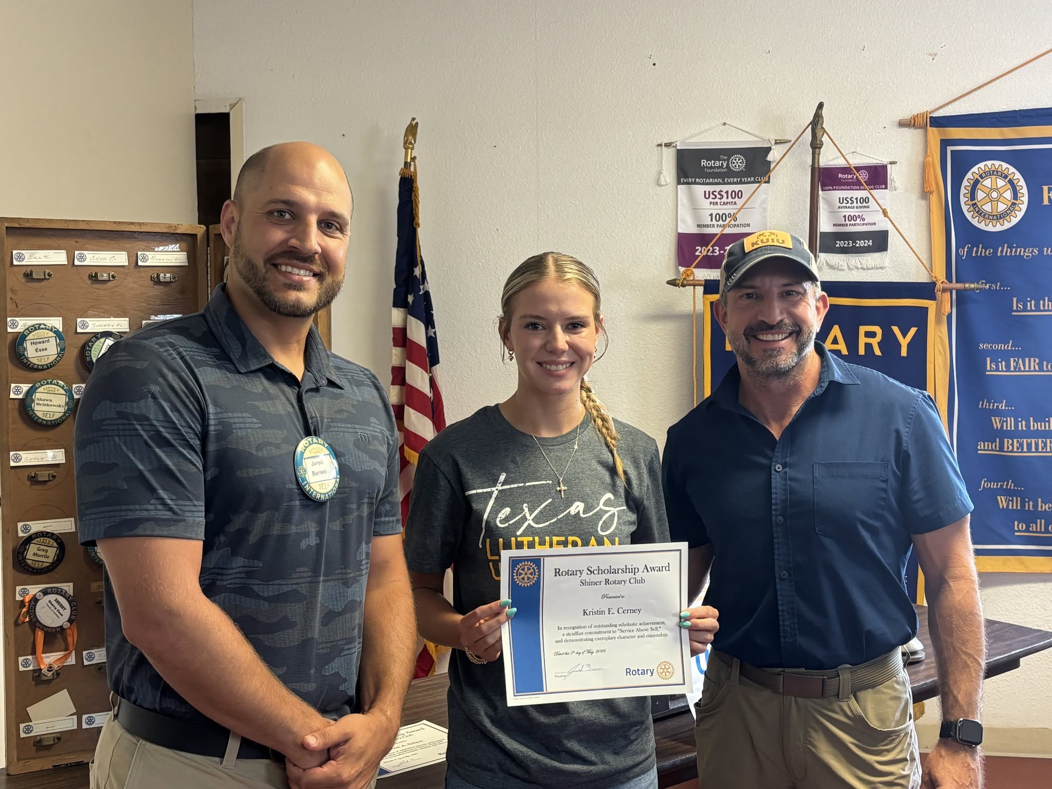 A Shiner Rotary scholarship recipient holding an award with club members